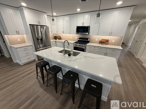 A modern kitchen with white cabinets and a central island.