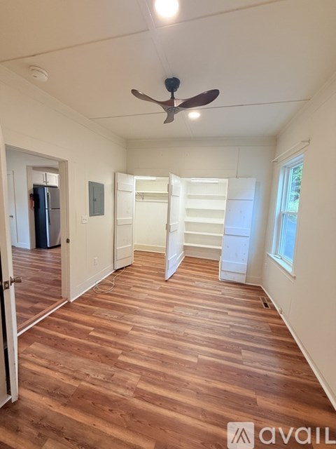 A room with wooden floors and a ceiling fan.