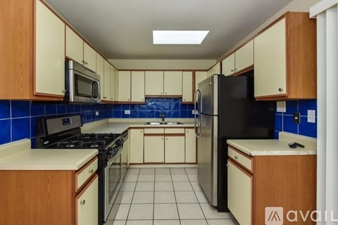 A kitchen with black appliances and wooden cabinets.