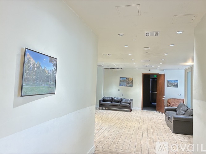 A living room with a couch and a painting on the wall.