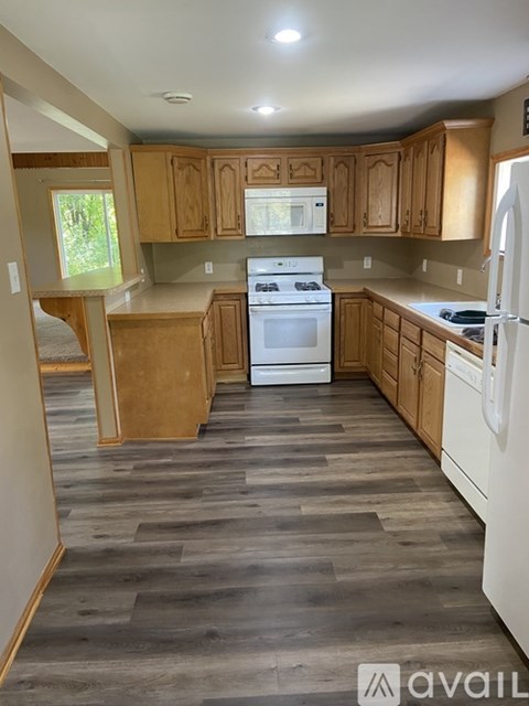 A kitchen with wooden cabinets and a white fridge.
