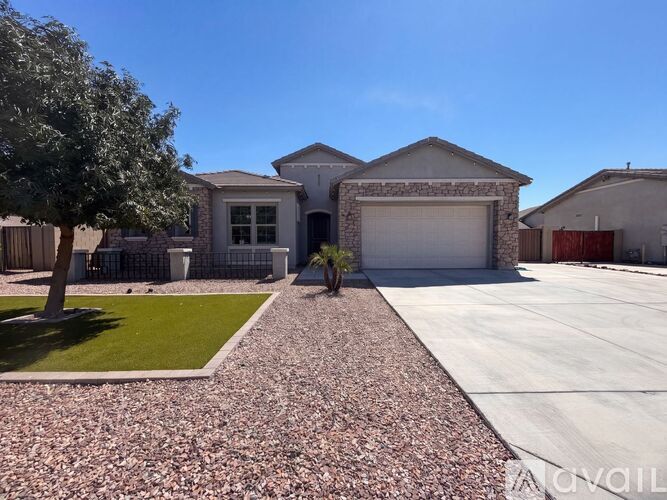 A house with a gravel driveway and a tree in front.