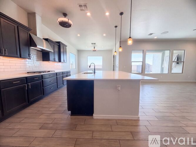 A kitchen with black cabinets and a white island.
