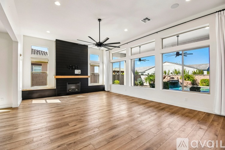A spacious room with a fireplace and a ceiling fan.