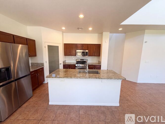 A kitchen with a granite countertop and stainless steel appliances.