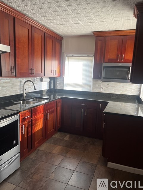 A kitchen with wooden cabinets and a black countertop.