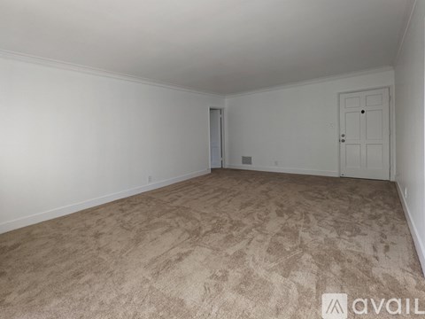 A room with beige carpet and white walls.