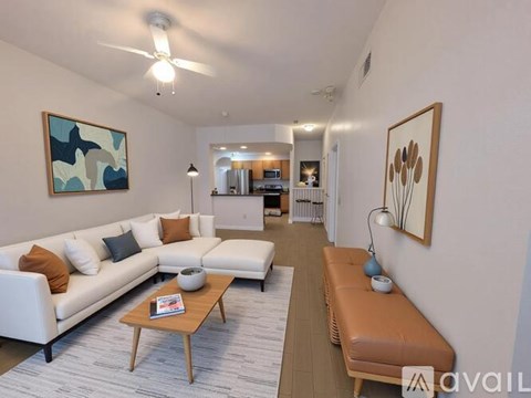 A living room with a white couch and a brown bench.