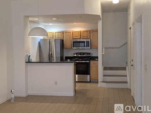 A kitchen with a refrigerator, microwave, oven, and sink.
