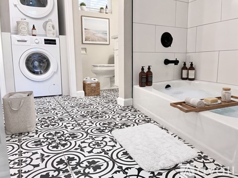 A bathroom with a black and white floor and a white tub.