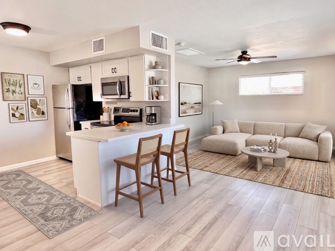 A kitchen with a bar stool and a couch in the living room.