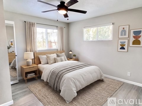 A bedroom with a large bed and a ceiling fan.