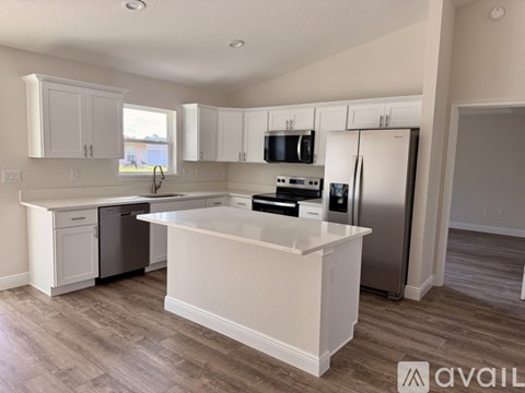 A kitchen with white cabinets and a large island.