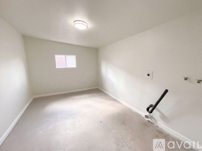 A room with a window and a light fixture on the ceiling.
