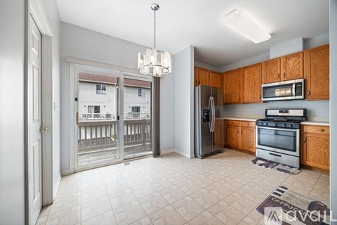 A kitchen with wooden cabinets and a refrigerator.