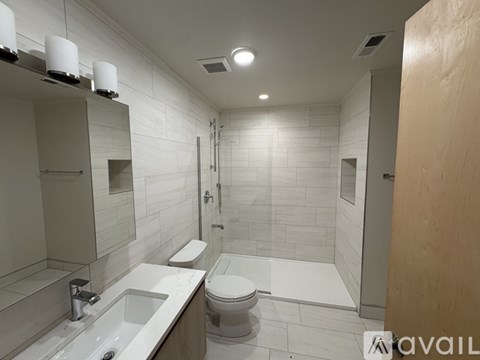 A bathroom with a toilet, sink, and mirror.