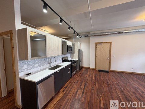 A kitchen with wooden floors and a white counter top.