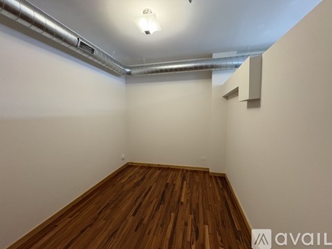 A room with wooden flooring and white walls.