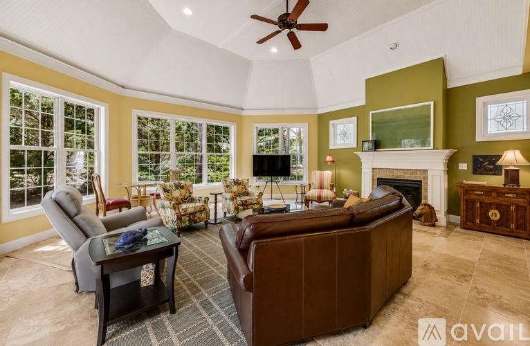 A living room with a brown couch, a coffee table, and a fireplace.