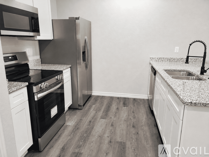 A kitchen with a stove, refrigerator, and microwave.