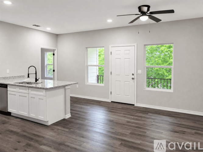 A spacious kitchen with a white countertop and a ceiling fan.