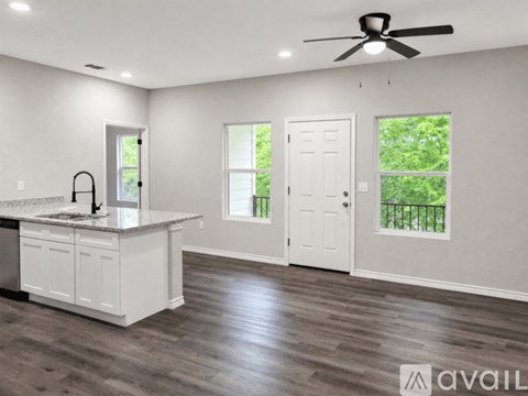 A spacious kitchen with a white countertop and a ceiling fan.