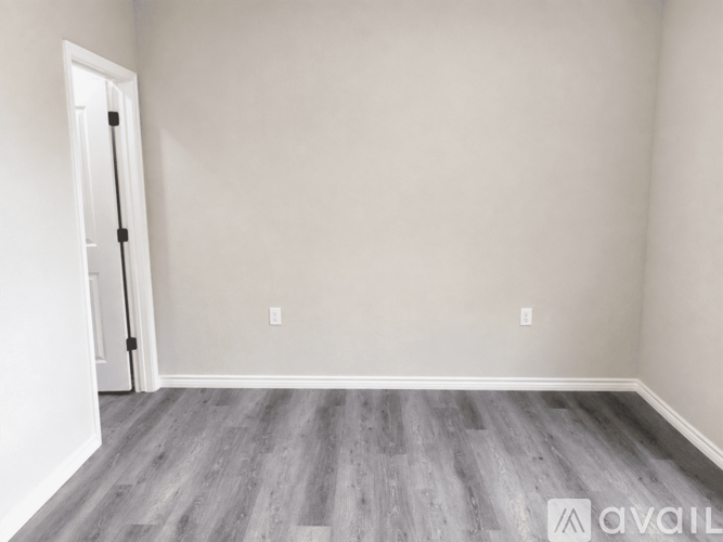 A room with a wooden floor and a white door.