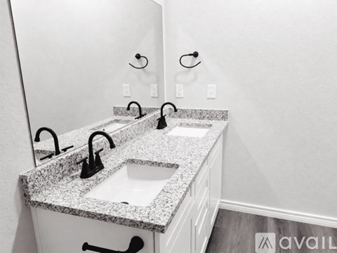 A bathroom with two sinks and a large mirror.