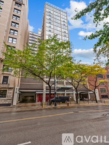 A street view with a building and a tree in the foreground.