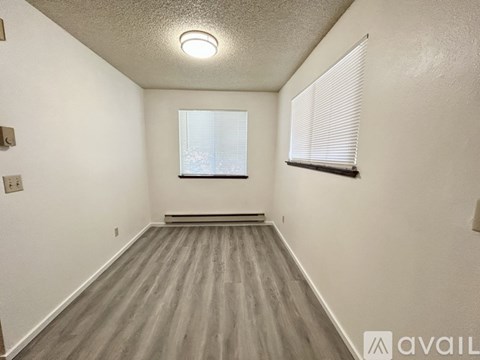 A room with a window and a wooden floor.