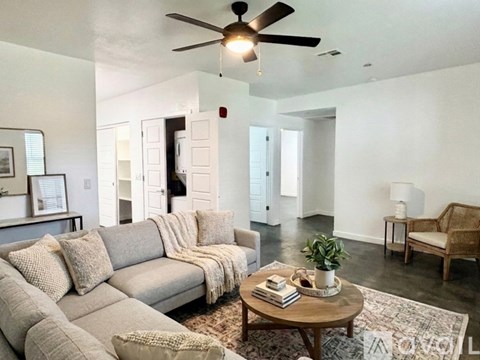 A living room with a grey sofa and a wooden coffee table.