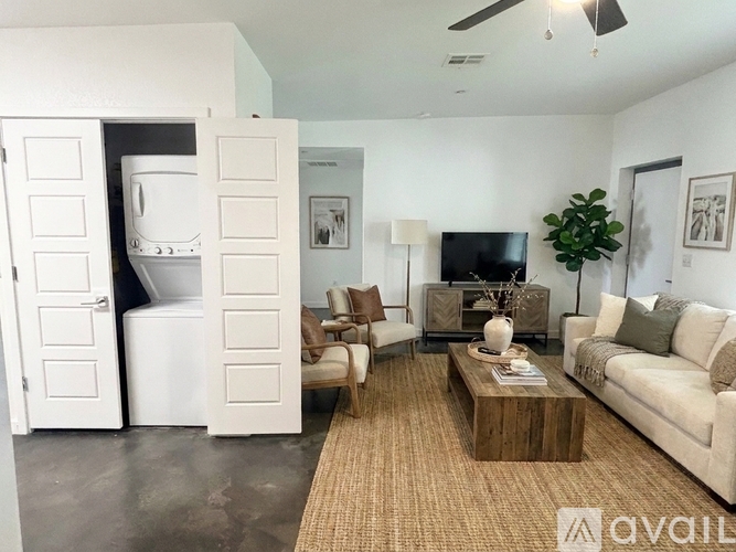 A living room with a couch, chairs, and a television.