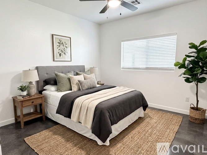 A bedroom with a large bed and a ceiling fan.
