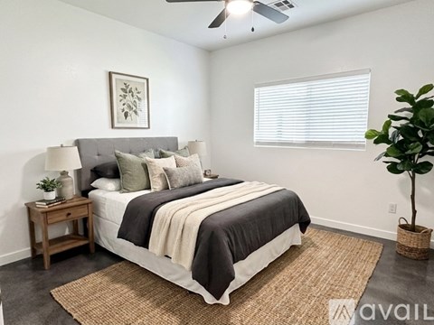 A bedroom with a large bed and a ceiling fan.