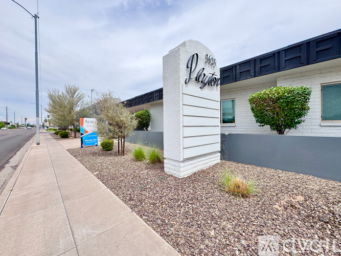 A white sign with the word "Parker" on it is in front of a building.