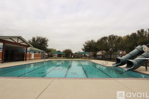 A large outdoor swimming pool with a slide.