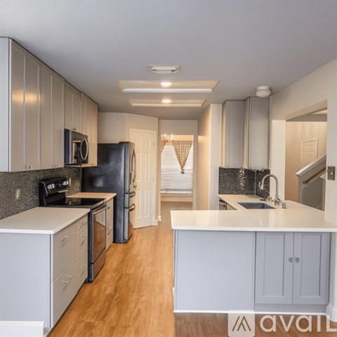 A kitchen with wooden floors and white appliances.