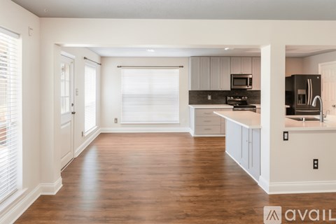A kitchen with white cabinets and a black fridge.