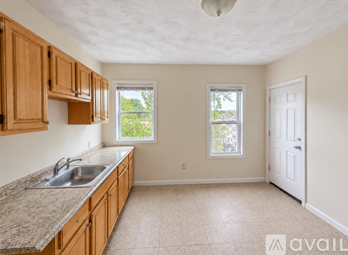 A kitchen with wooden cabinets and a granite countertop.