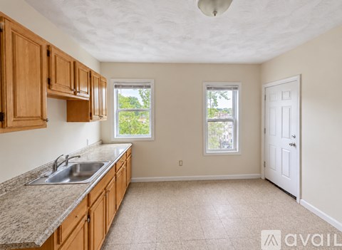 A kitchen with wooden cabinets and a granite countertop.