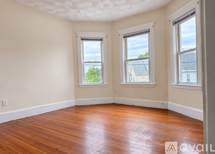 A room with wooden floors and two windows.