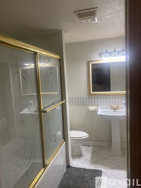 A bathroom with a toilet, sink, and a mirror.
