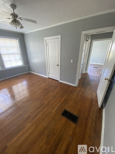 A room with wooden floors and a ceiling fan.