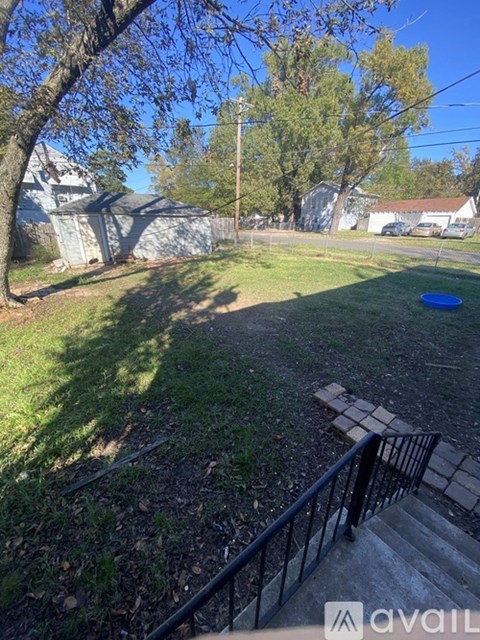 A backyard with a blue frisbee in the grass.