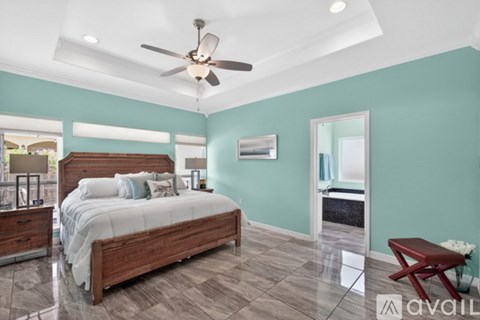 A bedroom with a large bed and a ceiling fan.