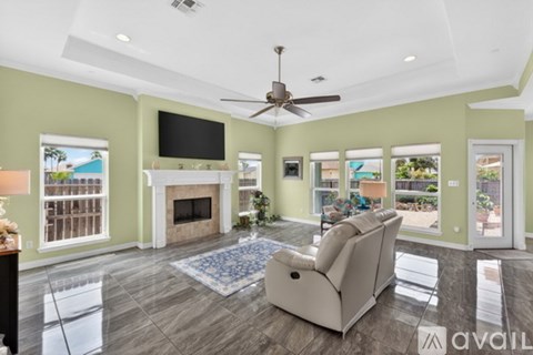 A living room with a fireplace and a television on the wall.
