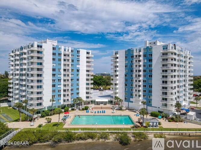 A large white building with a pool in front.