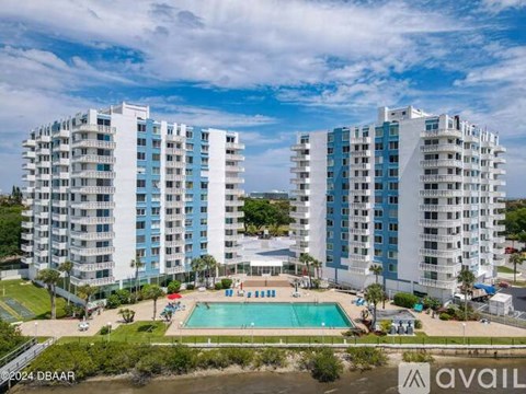 A large white building with a pool in front.