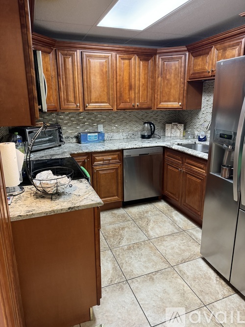 A kitchen with wooden cabinets and a marble countertop.