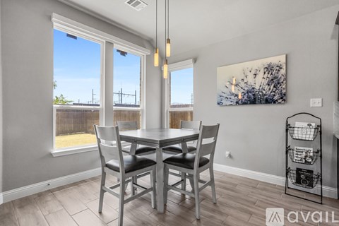 A dining room with a table and chairs.